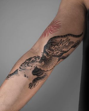 Experience the power of a tiger and the wisdom of a dragon in this stunning dotwork masterpiece on your arm by FKM TATTOO.