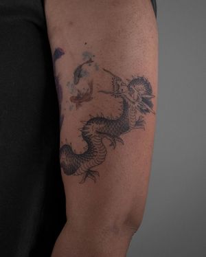 Capture the power and beauty of a traditional Japanese dragon with this intricate forearm tattoo by FKM Tattoo.