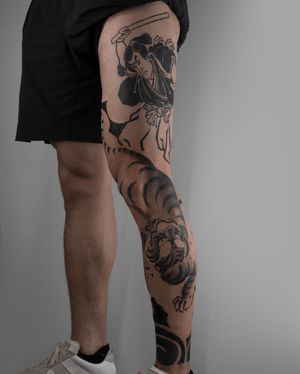Unique and fierce tiger tattoo on knee by FKM TATTOO, blending traditional Japanese style with modern dotwork technique.