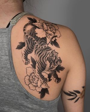 Experience the power and beauty of a Japanese tiger and flower in this striking black and gray illustrative design by FKM TATTOO.