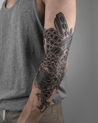 Get inked with a stunning black and gray illustrative raven design by FKM TATTOO on your arm. Embrace the mystique and beauty of this bird motif.