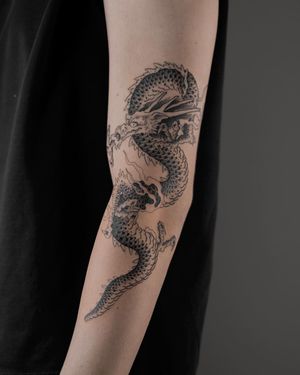 Experience the power of a fierce dragon in this striking black & gray Japanese tattoo by FKM TATTOO.