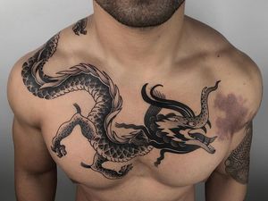 Epic blackwork dragon tattoo on chest, expertly done by FKM TATTOO in traditional Japanese illustrative style.