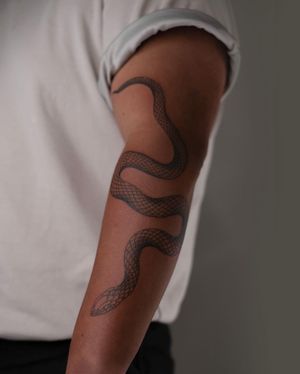 Elegant snake forearm tattoo by FKM TATTOO, featuring intricate fine line Japanese design.
