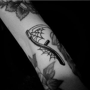 Ignorant blackwork tattoo by Jeff Huet featuring a spider and scythe motif on the forearm.