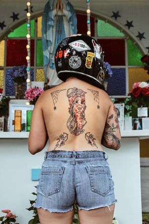 Stunning back tattoo by Jeff Huet featuring a delicate fine line design of a spider and woman.