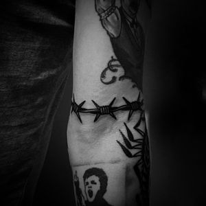 Bold blackwork design of barbed wire on arm by talented artist Jeff Huet. A striking and edgy addition to your tattoo collection.