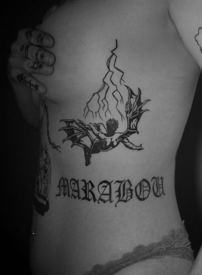 Get a dark and bold blackwork tattoo on your ribs with devil motif and personalized lettering by tattoo artist Jeff Huet.