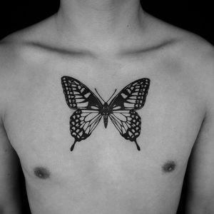 Experience stunning blackwork fine line butterfly tattoo on your chest by talented artist Jeff Huet.