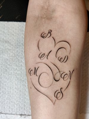 Get a delicate fine line tattoo by Mary Shalla, featuring a heart and small lettering on your forearm.