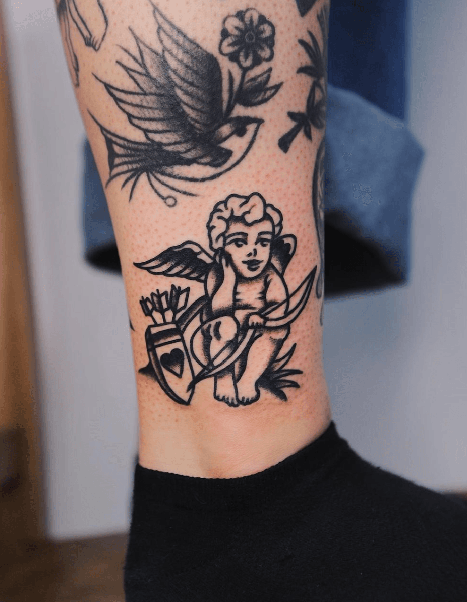 Traditional style cupid tattoo placed on the shin.