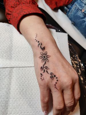 Experience the beauty of fine line floral art with this exquisite hand tattoo by talented artist Mary Shalla.