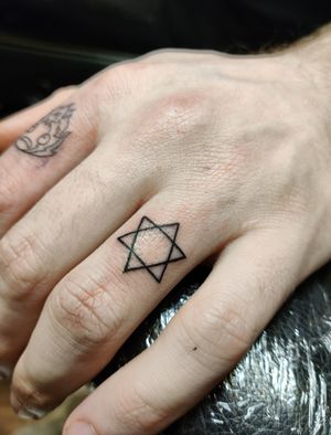 Elegant star tattoo on finger by renowned artist Mary Shalla, showcasing intricate fine line work.