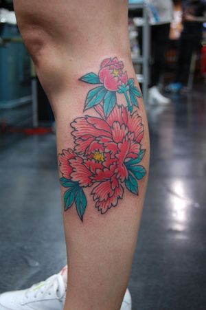 Beautiful neo traditional flower tattoo on lower leg by Bananajims, featuring vibrant colors and intricate details.