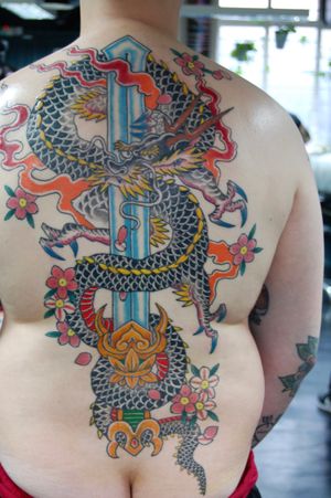 Breathtaking Japanese style back tattoo featuring a fierce dragon and a sharp sword, expertly inked by Bananajims.