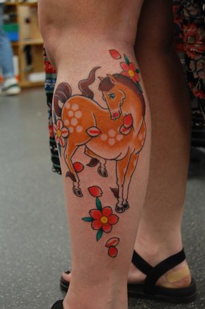 Experience the beauty of neo traditional art with a stunning horse and flower design on your lower leg by Bananajims.