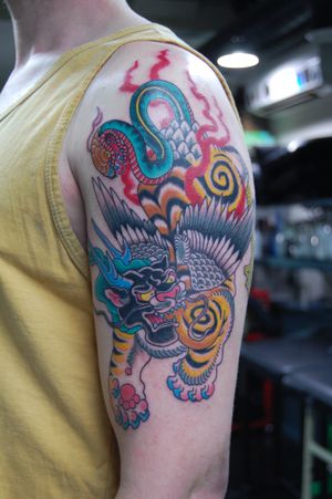 Experience the power and mystique of a traditional Japanese tattoo featuring a snake and a foo dog, expertly crafted by the talented artist Bananajims.