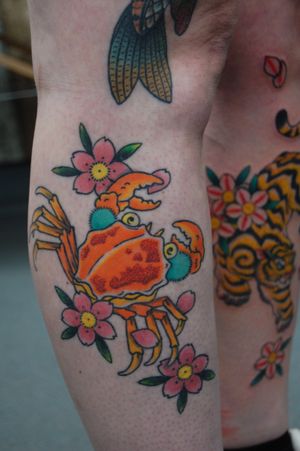 Get inked by the talented Bananajims with this unique design combining a delicate flower and a fierce crab motif. Perfect for your lower leg!