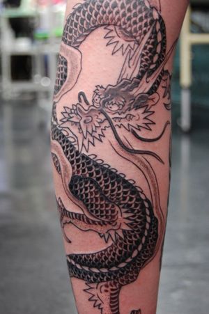 Capture the power and grace of a Japanese dragon on your lower leg with this stunning tattoo by Bananajims.