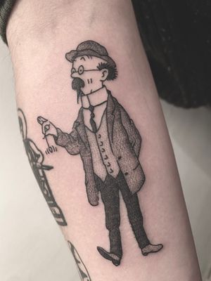 Get a stunning black and gray tattoo of Tintin and Tournesol on your arm by renowned artist Victor Martin.