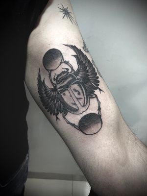 Get a stunning black and gray beetle tattoo by Victor Martin, blending neo-traditional and realism styles on your upper arm.