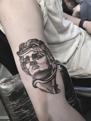 Unique upper arm tattoo by Victor Martin combining dotwork and realism styles, featuring a snake and statue motif.