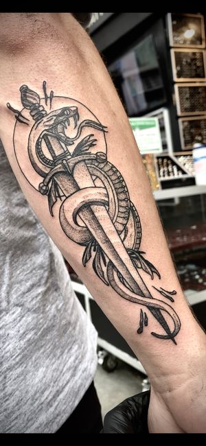 Victor Martin's unique dotwork style brings to life a striking snake and dagger design on the lower leg.