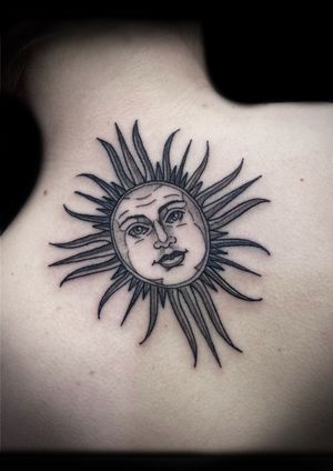 Get mesmerized by Victor Martin's stunning black and gray sun face tattoo on your upper back. Let the sun's energy shine through you.