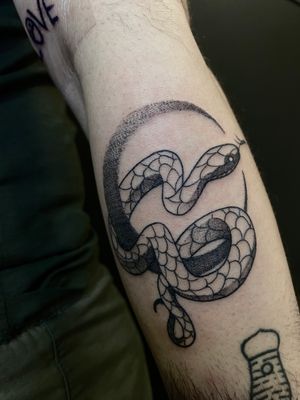 Elegantly designed snake tattoo by Victor Martin, expertly inked in black & gray on the forearm for a bold and stylish look.