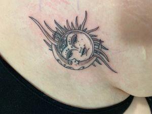 Elegant fine line tattoo on the upper leg featuring a sun and moon motif by Victor Martin.