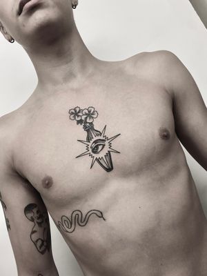 Victor Martin brings a touch of elegance with this black and gray neo traditional chest tattoo featuring a beautiful flower in a vase.