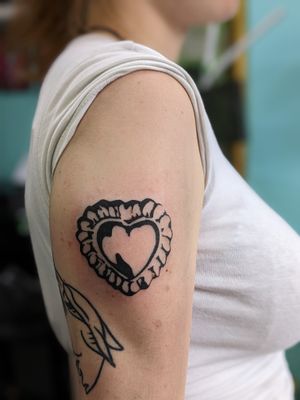 Elegant blackwork heart design on upper arm, expertly done by artist Luca Salzano. Perfect combination of delicate and bold.