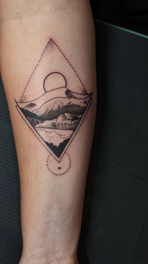 Explore the intricate beauty of nature with this geometric mountain landscape tattoo by artist Luca Salzano. Perfect for your lower arm.