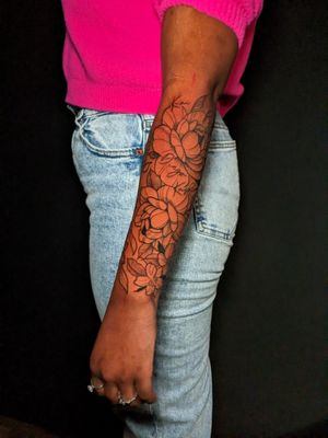 Elegant floral design by Luca Salzano, featuring delicate peony and intricate lines on the forearm.