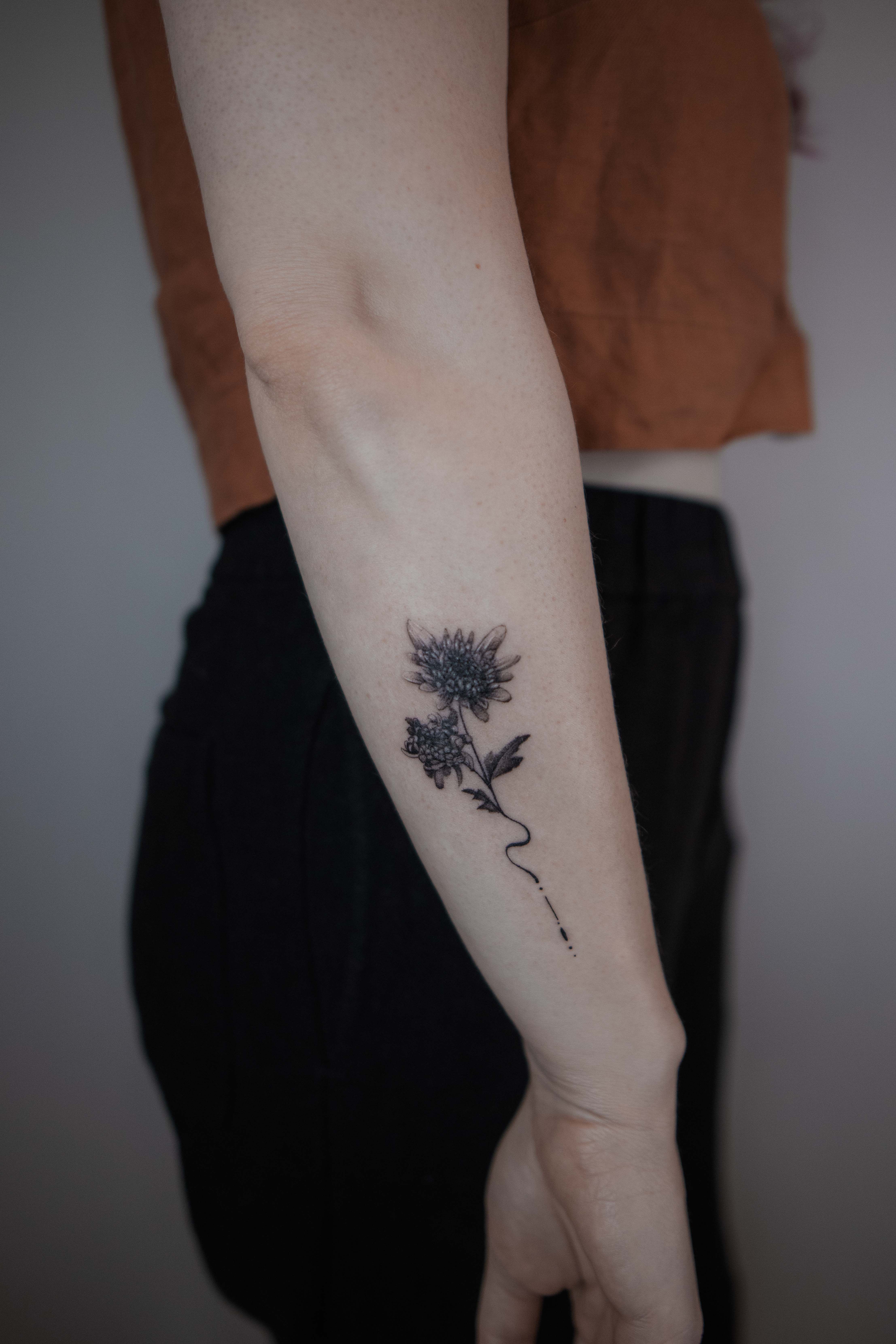 Minimalistic style chrysanthemum tattooed on the ankle