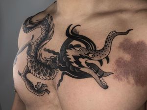 Experience the power of the mythical dragon with this striking blackwork chest piece by FKM TATTOO. Embrace the ancient Japanese artistry.