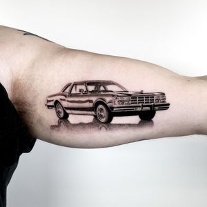 Experience the exquisite detail of micro realism in this upper arm tattoo featuring a lifelike car design by renowned artist Martin Rosenberg.