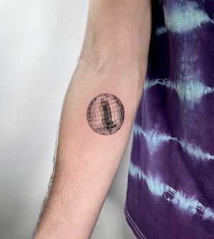 Get groovy with this micro-realism disco ball tattoo on your lower arm by the talented artist Martin Rosenberg.