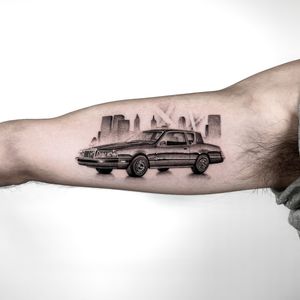 Get a stunning micro-realism car tattoo on your upper arm by renowned artist Martin Rosenberg. Perfect for petrolheads and car enthusiasts!