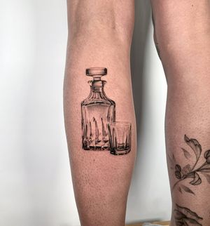 Experience the artistry of micro-realism with this stunning crystal whiskey glass tattoo on your lower arm. Perfect for whiskey lovers and fans of intricate tattoo designs. Created by the talented Martin Rosenberg.