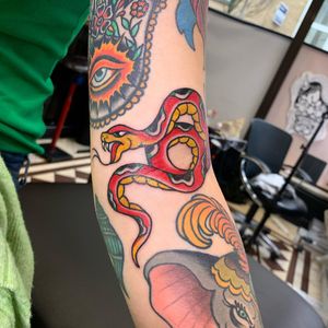 Get a striking traditional snake tattoo on your arm by the talented artist Laurel. This design will stand out and make a statement.