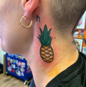 Traditional style pineapple tattoo on neck by Laurel, featuring bold colors and intricate detailing.