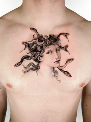 Experience the stunning combination of a snake and medusa in this black and gray realism chest tattoo by Delphin Musquet.