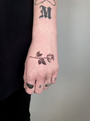 Beautiful black and gray floral design featuring a delicate rose, expertly done by Martin Rosenberg.