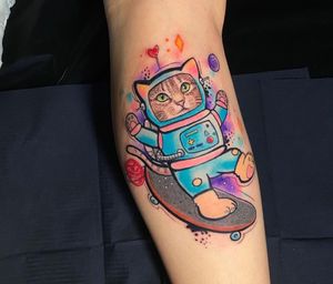 Get a unique twist on the classic astronaut tattoo with a new school style featuring a cute cat in London, GB.