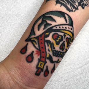 Get inked by Alessandro Lanzafame with this striking traditional design featuring a skull wearing a helmet on your forearm.