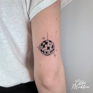 Get groovy with this detailed fine line disco ball tattoo by talented artist Chloe Mickham. Perfect for lovers of all things retro and sparkly!