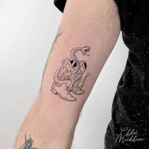 Unique and detailed fine line tattoo featuring a snake intertwining with cowboy boots, created by Chloe Mickham.