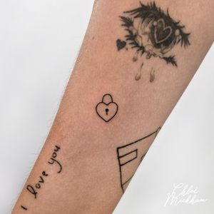Get this fine line tattoo featuring a minimal design of a heart and lock by the talented artist Chloe Mickham.
