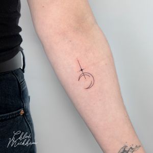 Fine line tattoo featuring a delicate moon and star motif, created with dainty precision by artist Chloe Mickham.